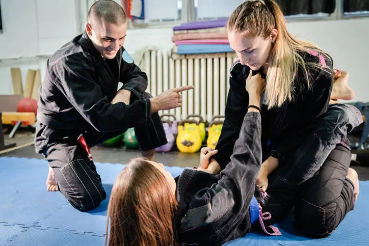 Jugendliche üben eine Selbstverteidigungstechnik im Training.